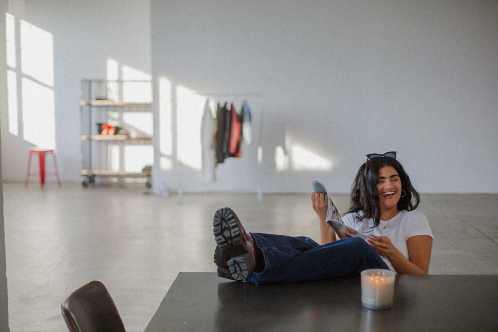 Model reading a fashion magazine with feet on table